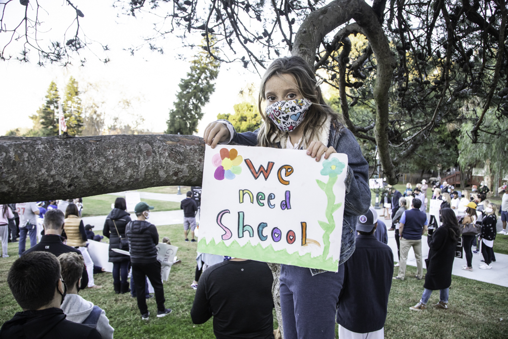 A young Manhattan Beach student rallies for returning to school. Photo by JP Cordero
