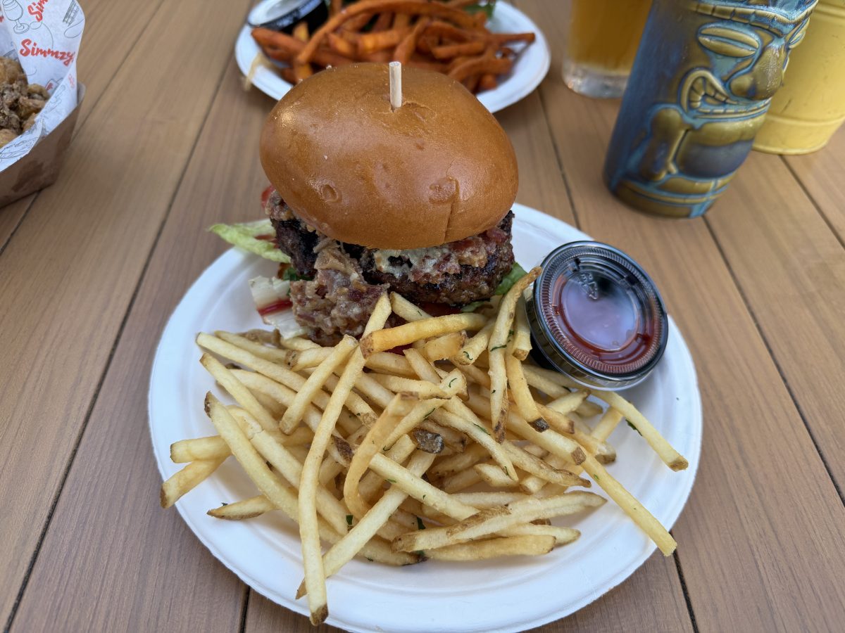 The turkey burger is dripping with sauce and flanked by a large portion of fries
